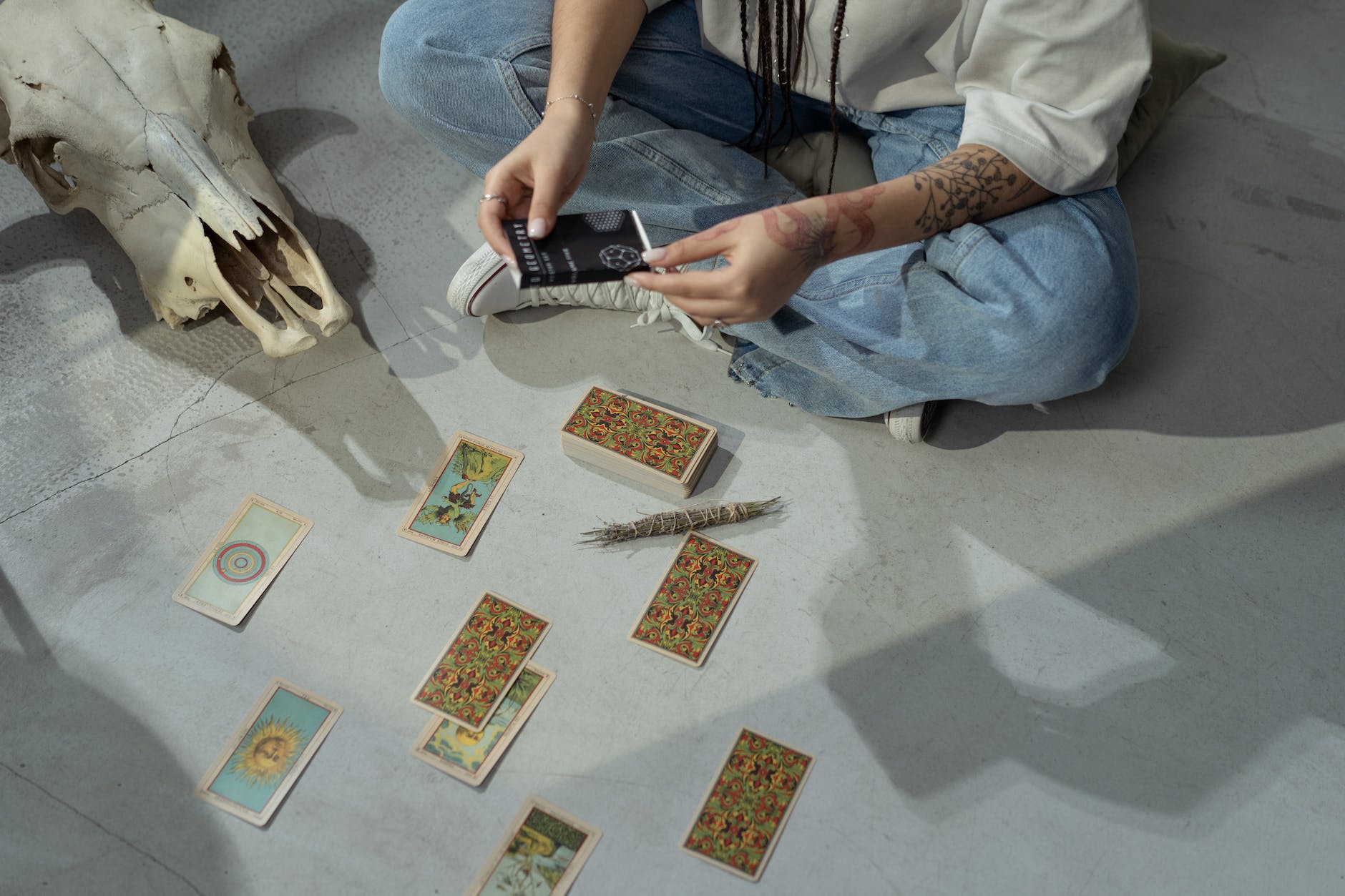 woman dealing tarot cards while sitting on the floor
