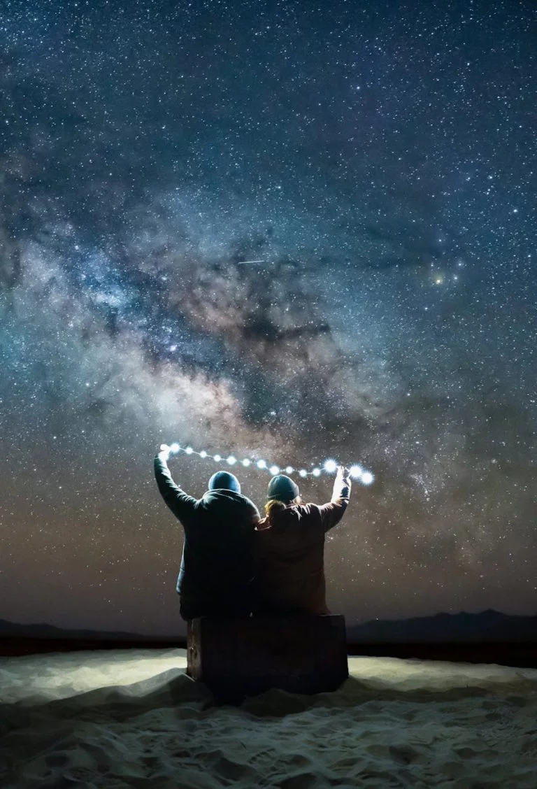back view of a couple holding light at night